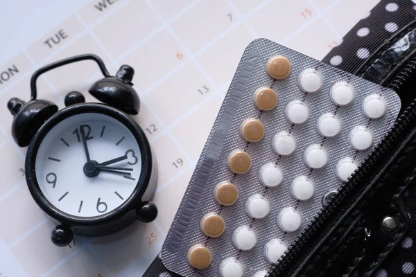 birth control pills , clock and calendar, close up