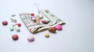 Masamızdaki sağlık sigortası konsepti dolar, konteyner ve haplar. 