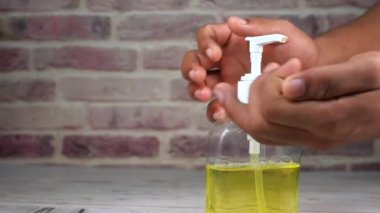 Genç adam virüsü önlemek için dezenfektan kullanıyor. 