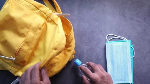 Student schooltas met ontsmettingsmiddel, een gezichtsmasker. — Stockvideo