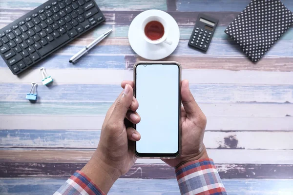 Flache Zusammensetzung der Hand hält Smartphone auf weißem Hintergrund — Stockfoto