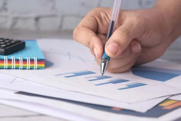 Mano de las mujeres con pluma analizando gráfico de barras en papel — Foto de Stock