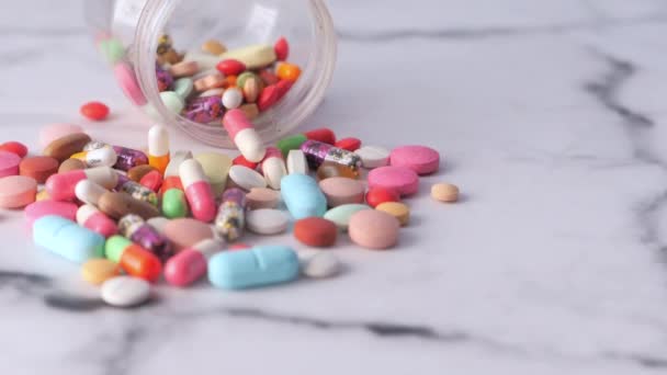 Close up of colorful pills spilling from container — Stock Video