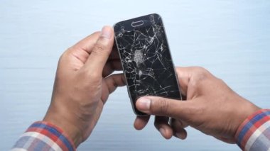 Kırık akıllı telefonu tutan adama yakın dur..