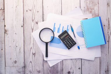 finansal grafik, hesap makinesi ve not defteri masanın üzerinde 