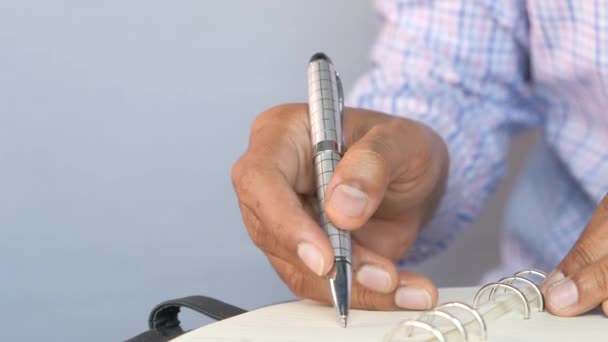 Primer plano de la escritura manual del hombre en el bloc de notas. — Vídeo de stock