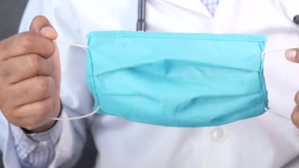 Primo piano del medico mano tenendo maschera chirurgica — Video Stock