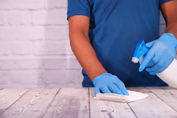 Masa yüzeyini temizlemek için dezenfektan spreyi kullanan tek kullanımlık eldivenler. — Stok fotoğraf