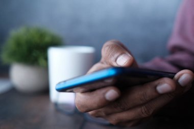 Akıllı telefon kullanarak genç adamın elini kapat..