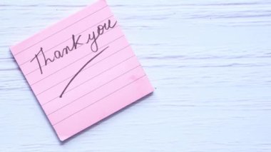 Beyaz arka planda lale çiçeğiyle yapışkan notta teşekkür ederim. 