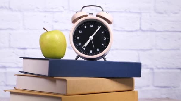 Чорний до школи концепція з яблуком і годинником на стопі книг — стокове відео