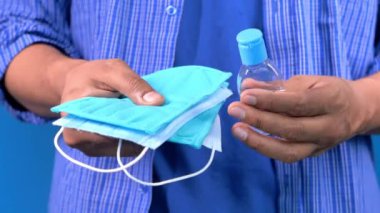  Adamın elinde cerrahi maske ve dezenfektan jeli var. 