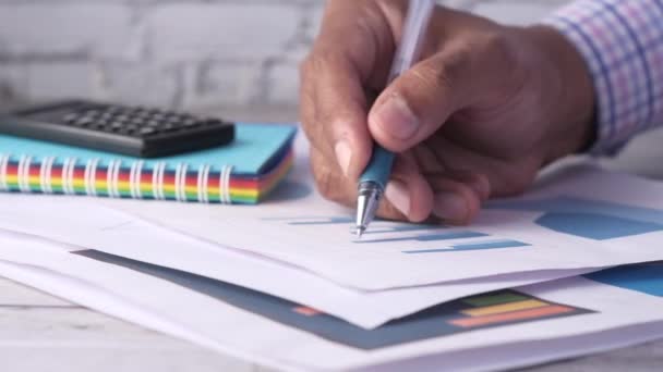 Mão homem com caneta analisando gráfico de barras no papel — Vídeo de Stock