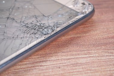 Ahşap arka planda kırılmış akıllı telefon 