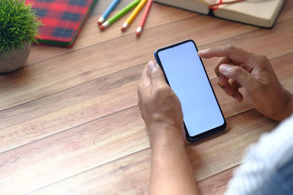 Arka planda ahşap arka planda akıllı telefonu tutan el görüntüsü 