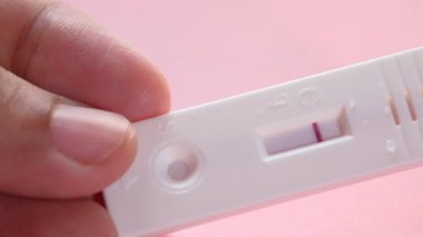 Hamilelik testi setini ahşap bir masada tutarken..