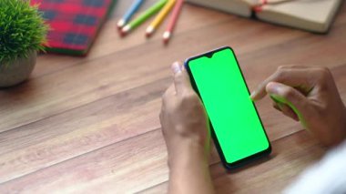 Arka planda ahşap arka planda akıllı telefonu tutan el görüntüsü 