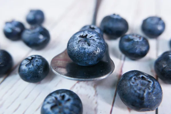 Close up of fresh blue berry fruits on spoon — Stock Photo, Image