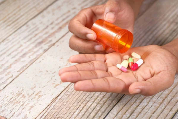 Primer plano de la mano del hombre tomando la medicina — Foto de Stock