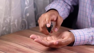 Virüsü önlemek için dezenfektan jel kullanarak genç adamın elini kapat. 