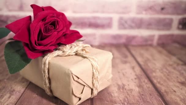 Close-up van roos bloem op een geschenkdoos op tafel — Stockvideo