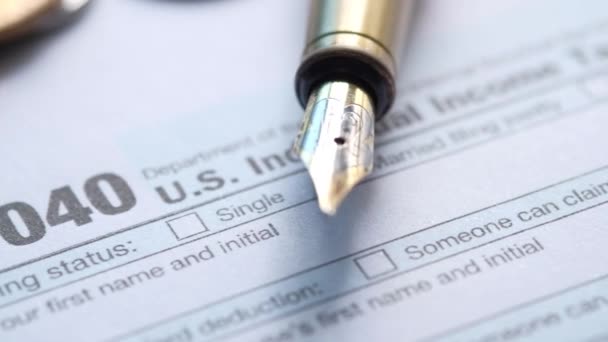 Sluiten van een belastingaangifte formulier en pen op tafel. — Stockvideo