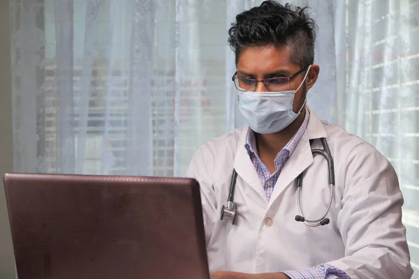 Médico em máscara protetora usando laptop no hospital. — Fotografia de Stock