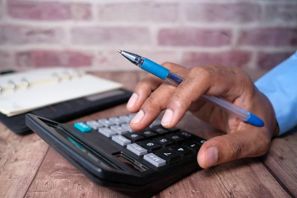 Primer plano de la mano del hombre usando la calculadora — Foto de Stock