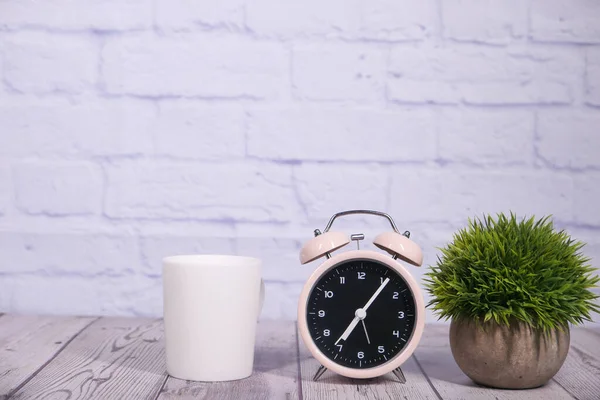 Taza de café y el reloj en la mesa de cerca —  Fotos de Stock