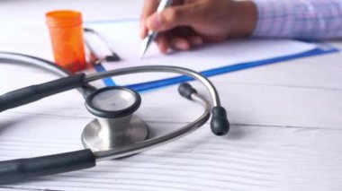Steteskop, beyaz kağıt ve haplar klinik masasında. .