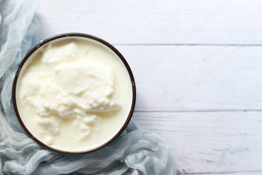 close up of fresh yogurt in a bowl on wooden background 