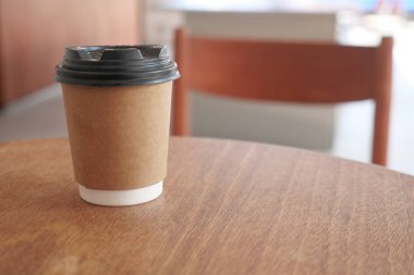 Bir kahve fincanı bir kafedeki ahşap bir masada oturur..