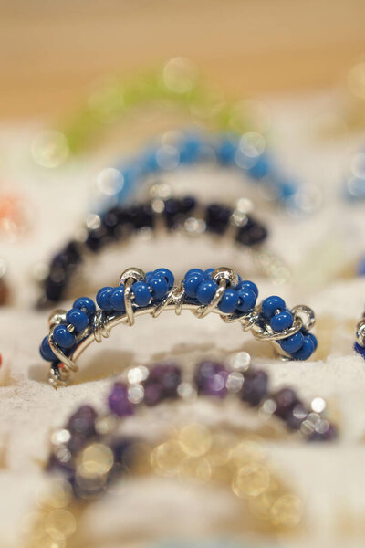 Brightly colored handmade rings showcased on a craft market table.