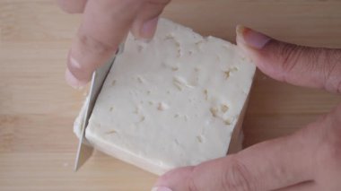 Bıçak, tahta kesme tahtasındaki taze peyniri dilimlemek için kullanılır..