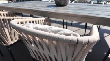 Saf sandalyeler ve doğal dekorasyon malzemelerinin yer aldığı zarif bir açık hava alanı..