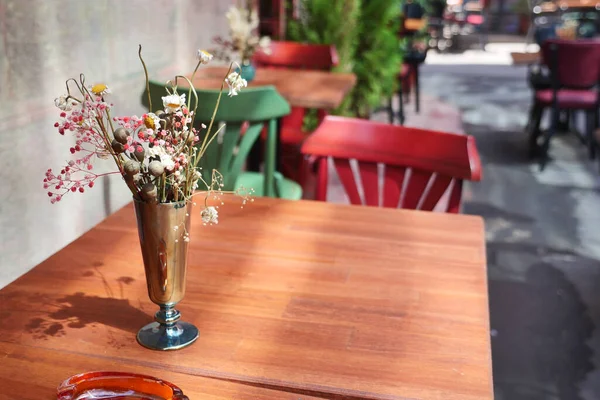 Canlı masaları ve taze çiçekleri olan büyüleyici bir açık hava oturma alanı..