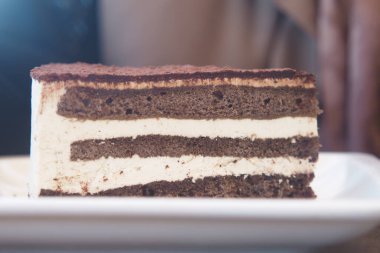 Bir tabakta sunulan kremalı çikolatalı pasta katmanları..