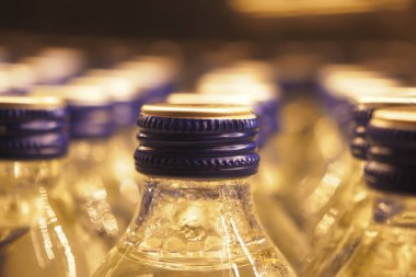 Soğutulmuş su şişeleri markette ışığı yansıtır, canlandırıcı içecekler için hazırdır..