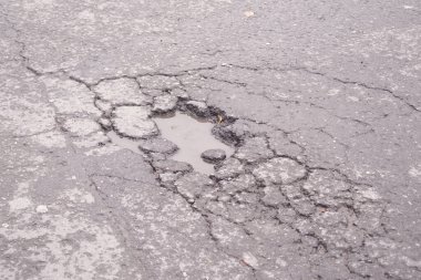 Suyla dolu büyük bir çukur şehrin kaldırımlarını bozuyor..