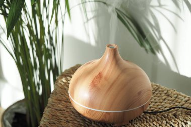 Ahşap aromaterapi, yeşil bitkilerin yanında buhar yayar..