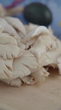 Renkli malzemelerle dolu bir mutfakta taze mantar dilimlemek..