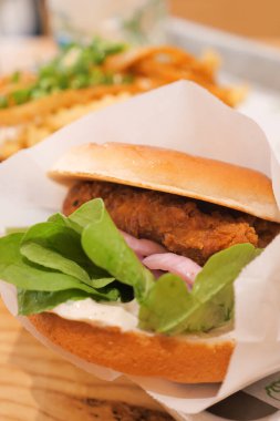 Kızarmış tavuklu sandviç, kıtır marul ve soğan turşusu..