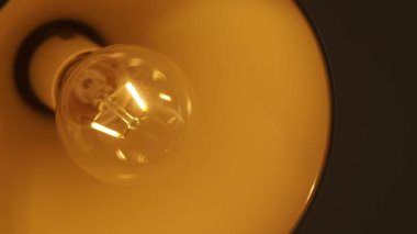 Sıcak bir ışık, yumuşak bir parıltıyla rahat bir alanı aydınlatır..