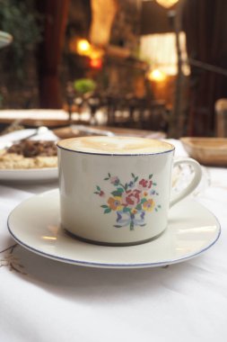 İyi işlenmiş bir fincan kahve zarif bir şekilde masanın üzerinde oturur..