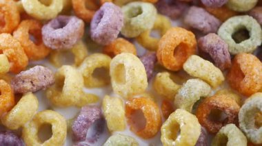 Kahvaltıda süt içinde yüzen canlı mısır gevreği halkalarıyla dolu bir kase..