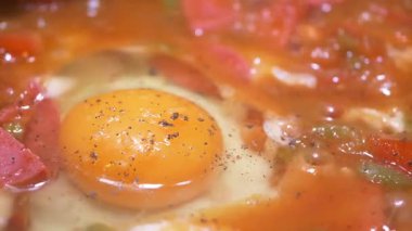 Taze domates ve canlı bir yumurta lezzetli bir yemek için birleşir, yavaşça pişirilir..