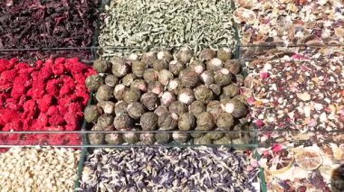 Çeşit çeşit kurutulmuş bitki ve çiçeklerle dolu canlı bir market tezgahı keşfedin..