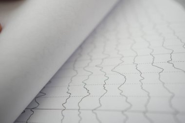 Bir el, veri satırlarını gösteren işaretlenmemiş bir grafik kağıdını çeviriyor.