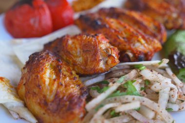 Domatesli sulu ızgara tavuk ve tabakta taze salata..