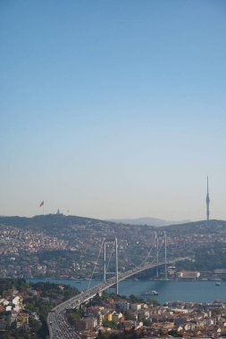 İkonik köprü arka planda tepeler ve şehirlerle körfezi kaplar..